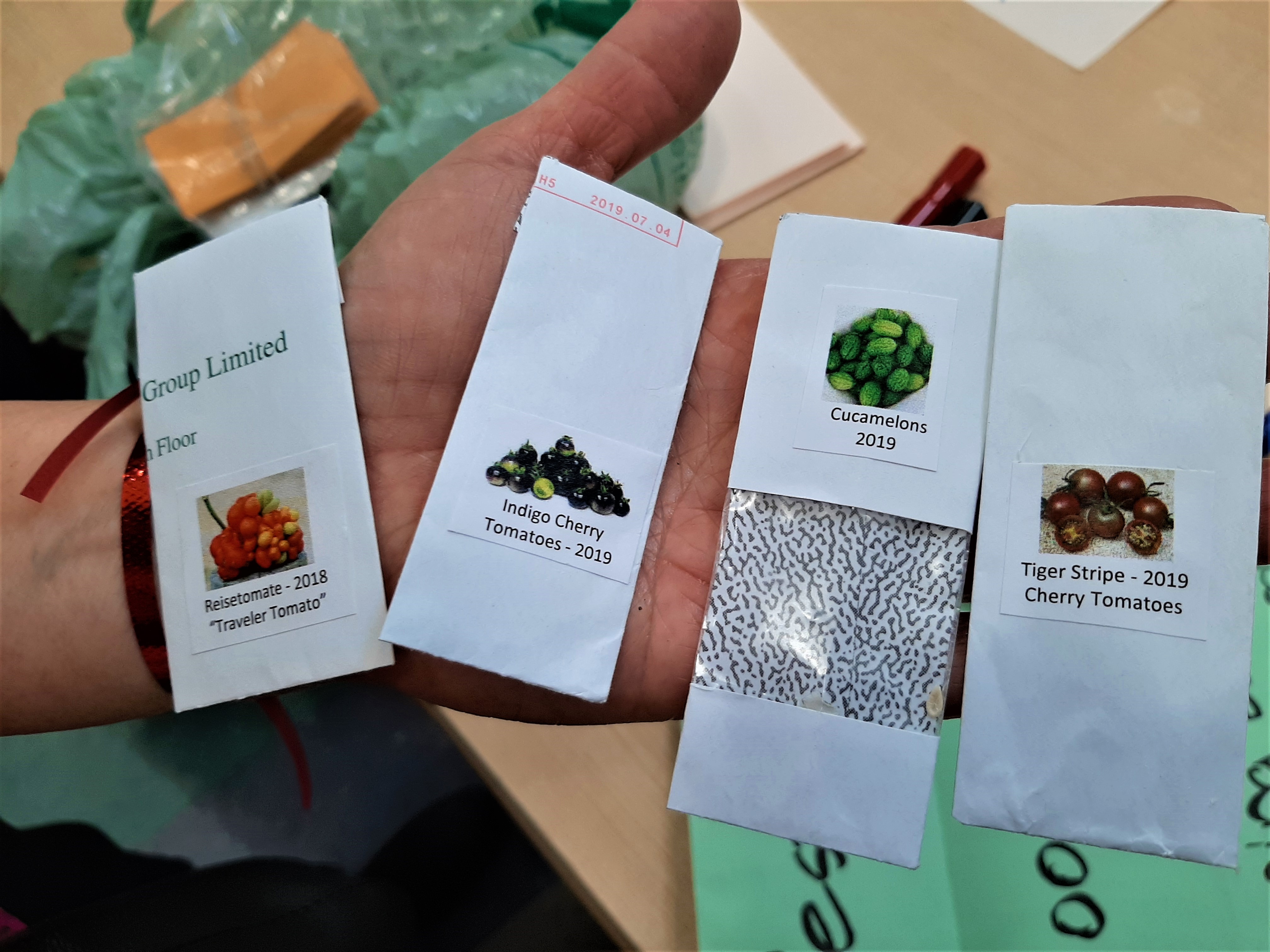 hand holding packages of seeds